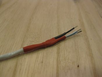 Landing light cable end reinforced with heat shrink